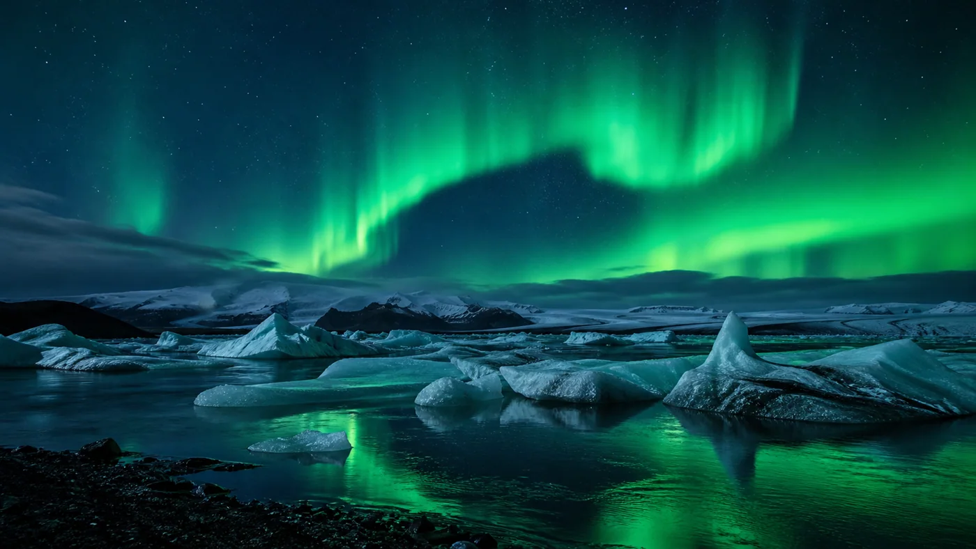 Green Fire Over Ice Lagoon — Aurora, ice, cobalt water, and black shore create cosmic realism.